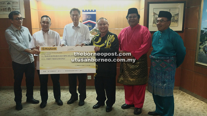 (From second left) Ching and Ho symbolically present the contribution to Chan. Also seen from right are Kuching South Deputy Mayor Hilmi Othman, Kuching Festival Food Fair organising chairman councillor Mohamad Taufik Abdul Ghani and a representative from Samling who did not wish to be named.