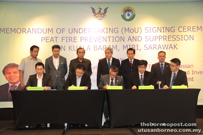 Awang Tengah (standing third right) and others witnessing the MoU signing between NREB and four corporate land owners.