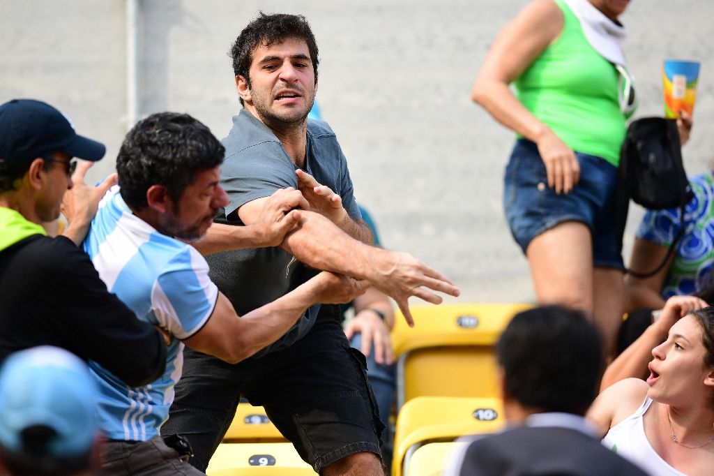 An Argentina fan fights with another fan during the tennis match between Argentina's Juan Martin Del Potro and Portugal's Joao Sousa on Aug 8, 2016. Photo by AFP
