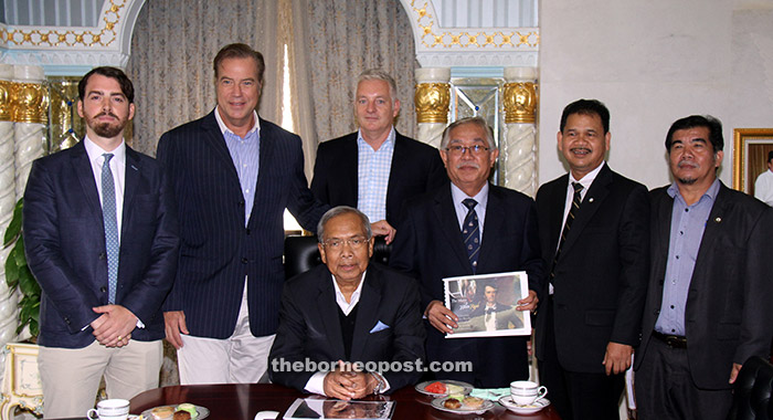 Jason (left) and the visiting entourage (from second left) Allyn, Fawcett, John Sikie including Ik Pahon (second right) have their pictures taken with Adenan (seated). — Photo by Chimon Upon