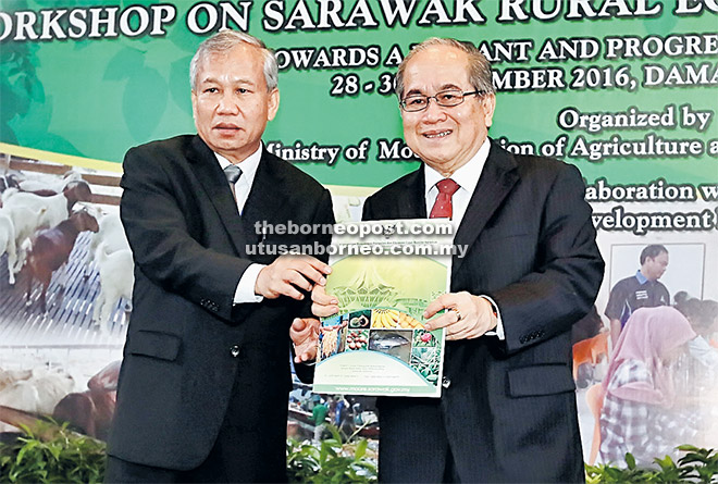 KELAI PEMUJUR: Uggah (kanan) nerima bup pasal pemujur pengawa betanam betupi di Sarawak ari Ngenang. 