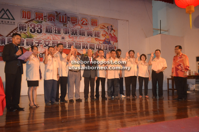 Siau Kui (sixth left) leads his committee members in the oath-taking, witnessed by Jamit (right).