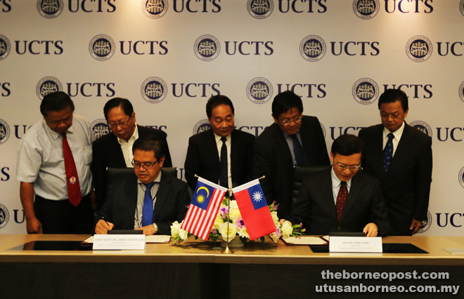 (Seated, from left) Dr Abdul Hakim and Dr Lee sign the MOU, witnessed by Lau, Wong (standing, second left and centre, respectively) and others.