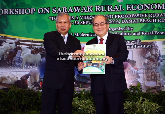 Ngenang (left) presenting a token of appreciation to Uggah. 