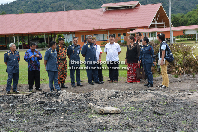 Soiman (sixth left) visits the scene of the fire. Long Lama District Officer Baru Tai is at eighth left. 
