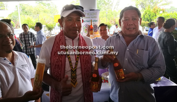 BERKHASIAT: Nogeh dan Pak Sabri menunjukkan produk madu kelulut yang dipamerkan sempena Kelulut Walk 2016 di Dewan Suarah Bau semalam.