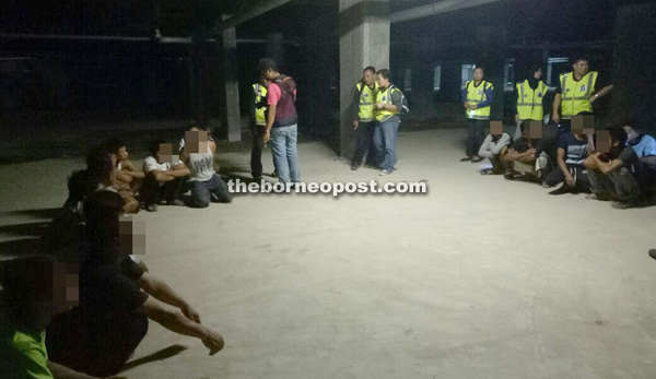 Police check foreign and local construction workers at a site in Jalan Tun Jugah.