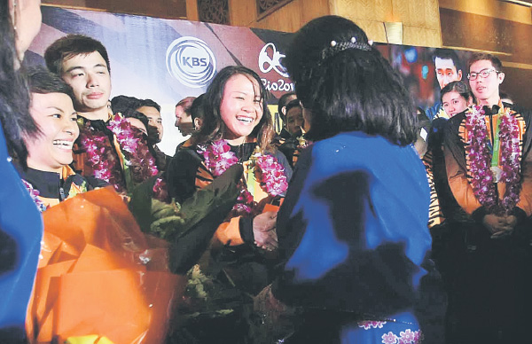 Pandelela (third left) and others greeted on arrival at KLIA yesterday. 