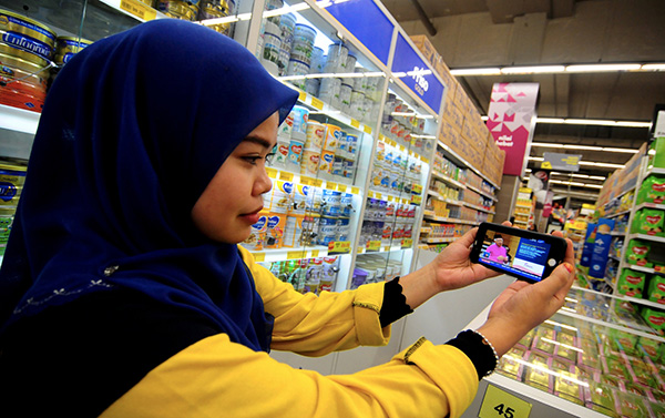 Shopping mall employee Nur Aini Raihan Shamsudin, 26, watches Prime Minister Datuk Seri Najib Tun Razak table Budget 2017 in Parliament ‘live’ on her mobile phone in Bukit Mertajam, Penang on Oct 21. — File photo