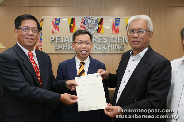 Shukarmin (right) and Tan hold the appointment letter while Dr Sim looks on.