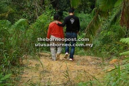 SELESAI: Suspek utama diiringi polis ke kawasan senapang patah yang dipercayai digunakan dalam kes tembak di Ulu Sungai Arip.  