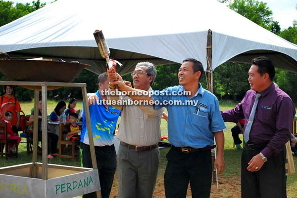 Yakup (left) and Abang Zainal light the cauldron for the tournament.