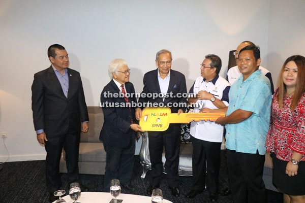 (From second left) Abdul Hamid and Adenan present a mock key to Watson while Abdul Latif (fourth left) and others look on.