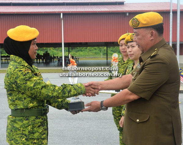 Awis (right) hands over a certificate of participation to a Rela member at the closing of the course in Sibu.
