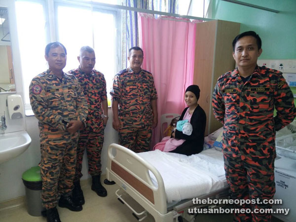 Firemen paying a visit to Zuraidah and her newborn son at SGH yesterday.