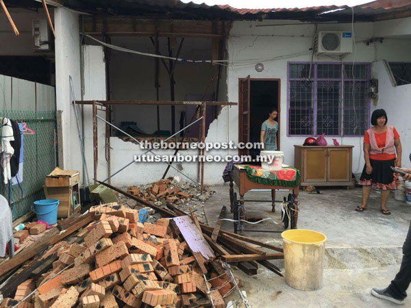 Teo (left) and her mother at their front yard which was ploughed down by a lorry.