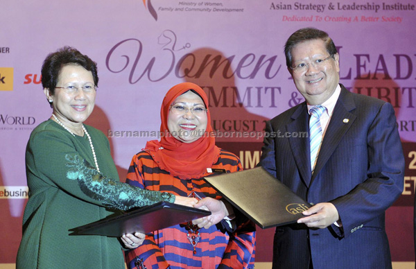 Rohani (centre) witnessing the exchange of documents between National Council for Women Organisations (NCWO) president, Tan Sri Dr Sharifah Hapsah Syed Hassan Shahabudin and ASLI chairman Tan Sri Jeffrey Cheah after giving her address at the ‘Women in Leadership Summit and Exhibition 2016’. — Bernama photo