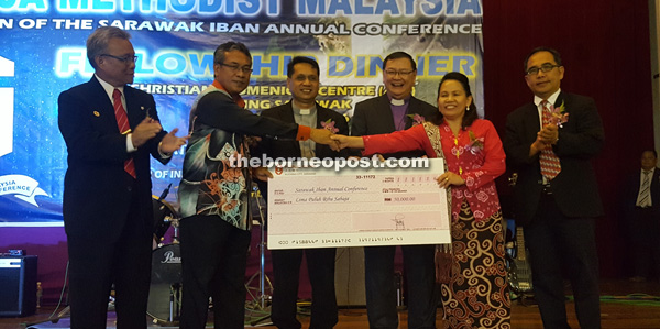 Nyabong symbolically presents the RM50,000 grant to a Sarawak Iban Annual Conference committee member. Ong is at third right.