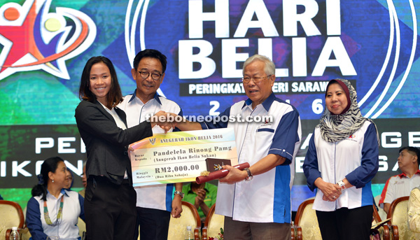 Manyin (second right) presents a mock cheque to Pandelela. Looking on are Abdul Karim and Rosey. 