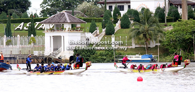 SAINGAN BERMULA: Peserta lumba bot naga memulakan saingan di Tebingan Kuching.