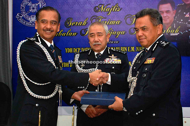 Abdul Rashid (centre) witnessing the handing over of duties of State Deputy Commissioner of Police from Awang Sahari (right) to Razarudin.