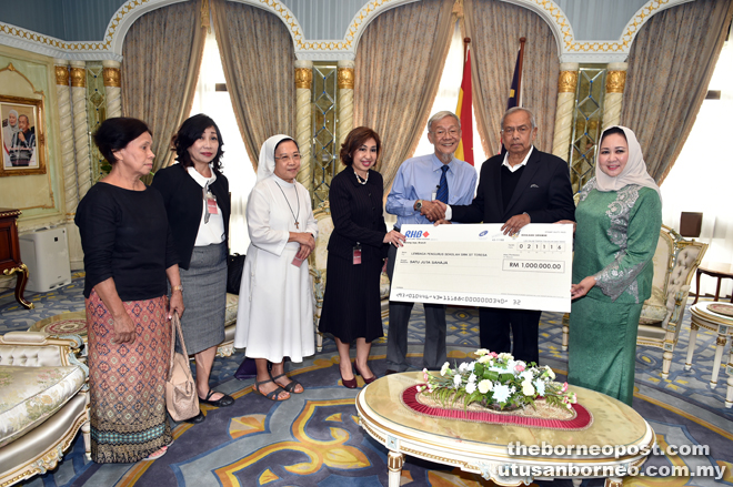 Adenan presents the mock cheque to Wong (third from right). Mary is fourth from left.