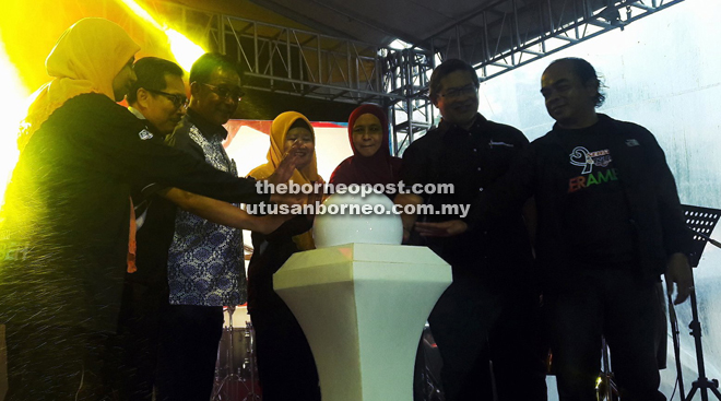 Karim (third left) and Salmah (fourth right) together with RTM senior officers place their palms on the globe in a symbolic gesture to declare open the Sehati @RTM Berambeh.