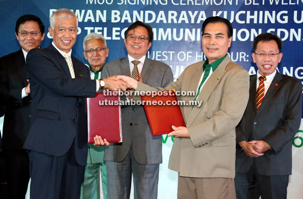 Abang Johari (third right) witnesses the exchange of documents between Abang Jemat (second right) representing PPTelecom and Abang Abdul Wahap representing DBKU. Looking on are Dr Sim (right), Abang Talhata (third left) and Dr Abdul Rahman. — Photo by Kong Jun Liong 