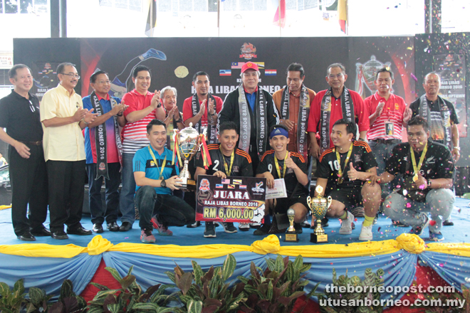 Paulus, Awang Tengah and Dr Abdul Rahman (standing fifth, seventh and eighth left, respectively) with the players of ‘Jalan Jalan Cari Makan A’, who managed to defend their title as the ‘Sepak Takraw King of Borneo’. 