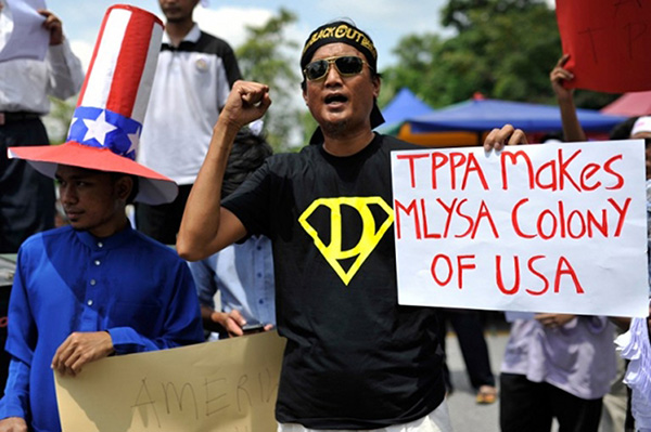 Demonstrator holding up a placard during a protest against Malaysia's participation in negotiations for the Trans-Pacific Partnership agreement in Kuala Lumpur. — AFP file photo