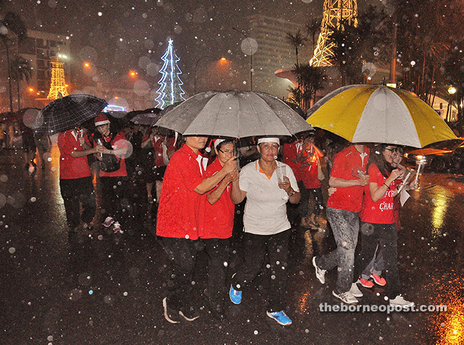 GLORY TO GOD: More than 10,000 people braved strong winds and downpour to take part in the annual Christmas parade in Sibu last night. It started to rain about 10 minutes after the start of the spectacle, which was hosted by St. John’s Church under Venerable Archdeacon Jamal Senada. — Photo by Othman Ishak. 