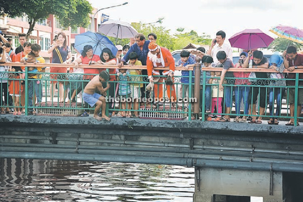 Santa Claus get ready to throw a duck into Seduan River as a contender gears up for the jump.