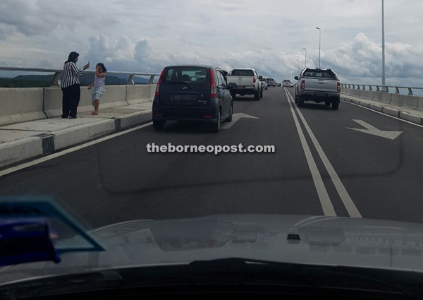 These motorists make a stop at a section of Batang Sadong bridge to take photos – a practice that is not only causing inconvenience to other road users, but can be dangerous.