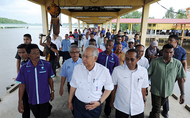 Najib (second left) visiting a jetty after speaking at a gathering with the local community in Kampung Nenasi Pantai. — Bernama photo