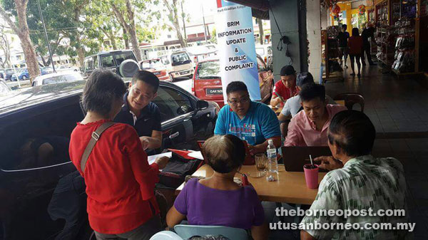 See (second left) and other PKR members assisting the public in updating their personal particulars for BR1M application at Tabuan Jaya last week.