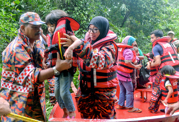 Fire and Rescue Department personnel evacuate  flood victims from Kampung Tok Kundor to the relief centre at Sekolah Kebangsaan Bukit Awang in Kota Bharu. — Bernama photo