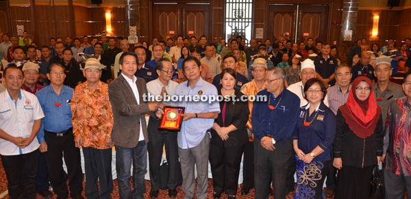 Dennis (left) presents a souvenir to Anyi.