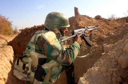 A Syrian soldier takes aim during clashes with Islamic State (IS) fighters near Deir Ezzor in November 2016 - AFP file photo