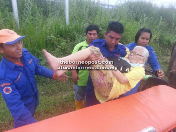 JPAM personnel helping an elderly woman to evacuate as her house was affected by the flood.