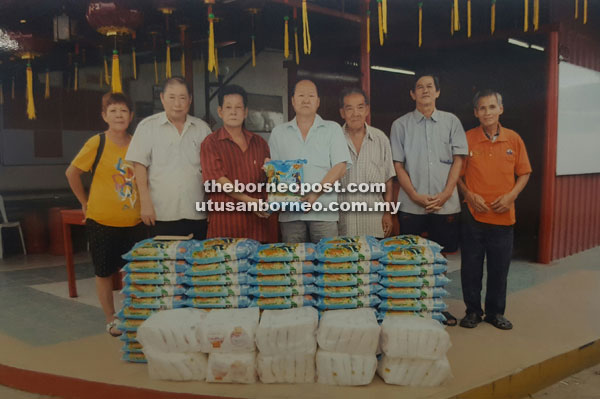 Lim (third left) handing over the donations to Ng recently while others look on.