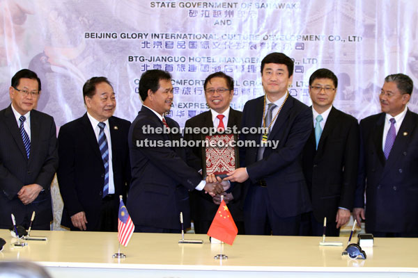 Abang Johari (centre) witnessing the exchange of MoU between Pahon and Liu. Also seen (from right) are Mohamad Morshidi, Fu, Wong and Lee. — Photo by Chimon Upon