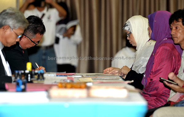 Jamilah  (second right)  submits the candidate’s form at the nomination centre in Dewan Masyarakat Lundu. — Bernama photo