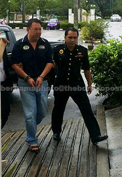 Kok (left) claimed trial at the Sessions Court with 28 counts of submitting fraudulent claims to a government-linked company three years ago. — Bernama photo