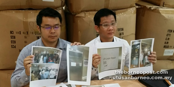 Tan (right) and Bong holding up printed images of the photos taken at SGH on Sunday. 