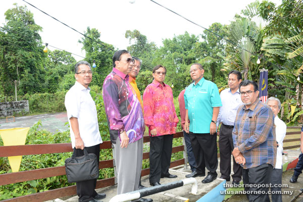 Abang Johari (fourth left), Abang Karim (second left) and others standing in front of what used to a government quarters, where he was born in 1950. Now a tennis court stands at the site.