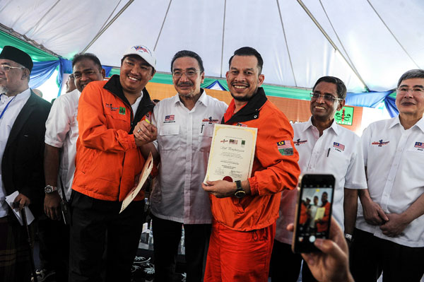 Hishammuddin (fourth right) presents the certificate of participation to ship captain Mohd Firdaus Faisal (third right) after welcoming back the Nautical Aliya ship and its crew and volunteers who had participated in the humanitarian ‘Food Flotilla for Myanmar’ aid mission, at the Boustead Cruise Centre in Port Klang. — Bernama photo