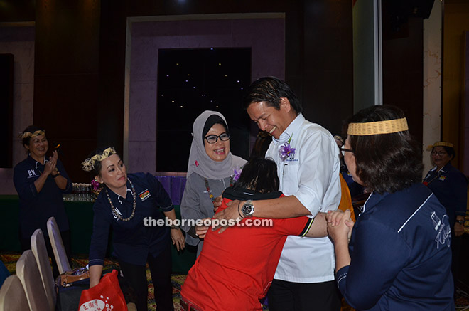 A special child from Telang Usan hugs Dennis after Fatimah (third left) presented gifts to the children.