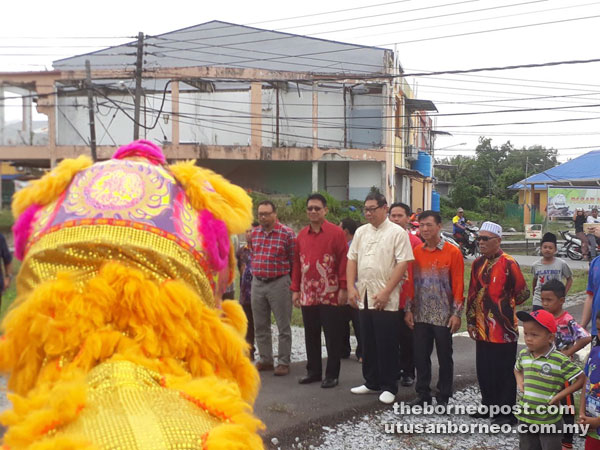 Julaihi (second left), flanked by Brahim on his right and Kapitan Lau, being welcomed by a lion dance performance upon arrival at the Chinese New Year gathering.