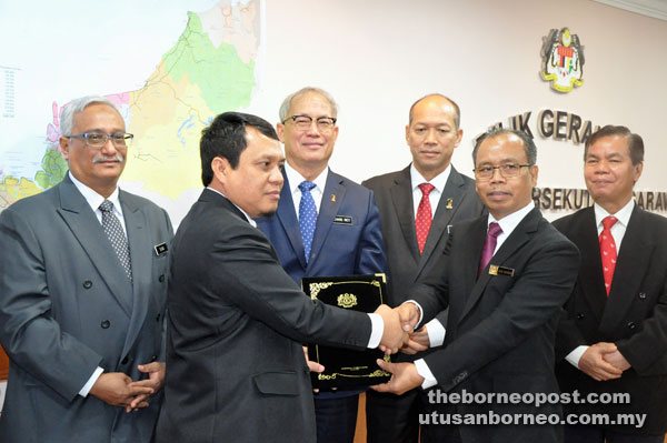 Riot (third left) looks on as Jack (second right) receives the documents from deputy director Sulaiman Ismail during the symbolic handing over of duties ceremony. Also in the photo are (from left) Human Resources Ministry deputy secretary general Datuk Mohamed Elias Abu Bakar, the minister’s political secretary Mejar (r) Datuk Peter Runin and former state Labour Department director August.