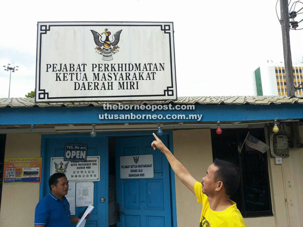 Dennis points at the signboard for the office where he claimed no Orang Ulu community leader was available.